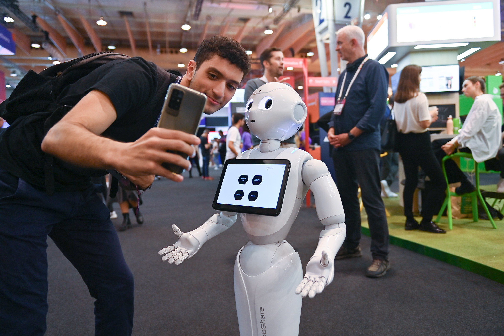 An attendee takes a selfie with AI Robot, Robshare from German Park