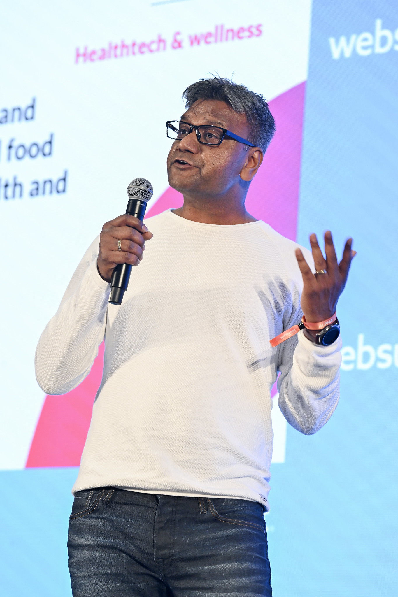 A photo of a person, Yogesh Gupta, founder and CEO of Gaston, speaking onstage at Web Summit. They are holding a microphone and gesturing with their hands.
