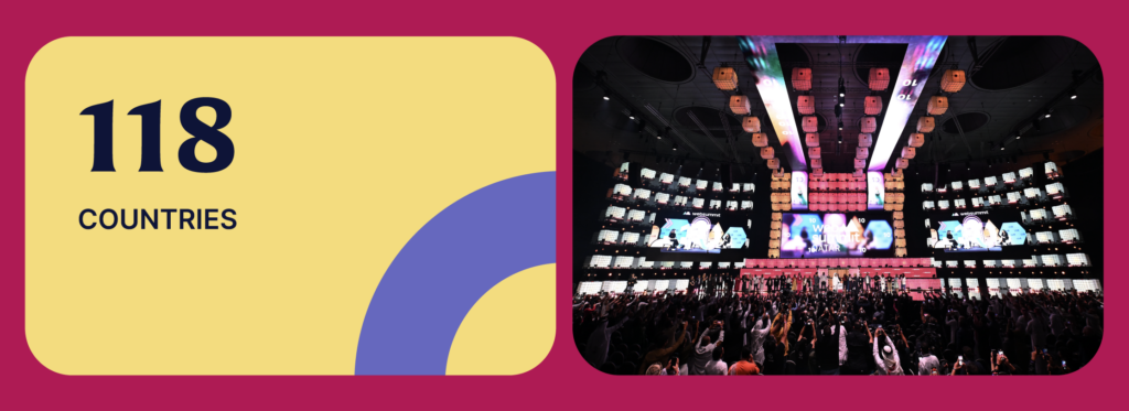 A banner-style image. On the right, a large stage viewed over the heads of a crowded audience. A large screen in the centre of the stage displays the Web Summit Qatar logo. Two slightly smaller screens on either side show images of stages from Web Summit in Lisbon. On the stage, a line of standing people faces the audience. This is Opening Night at Web Summit Qatar. On the left of the banner, text reads '118 countries'