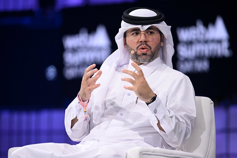 A photo of Mohammed Al-Hardan, head of tech at Qatar Investment Authority, on Centre Stage during Day 1 of Web Summit Qatar 2024. Mohammed is sitting on a chair and gesturing with his hands.