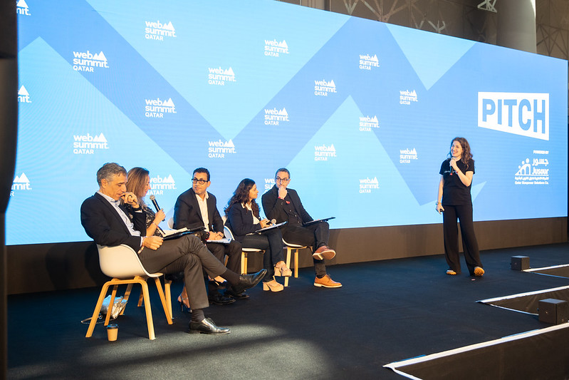 A startup founder pitches her company to a panel of judges on stage at Web Summit Qatar